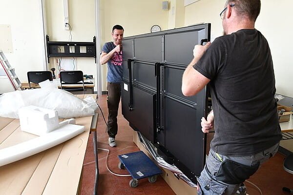 Andreas Zürner (links) und Patrick Felgentreu montieren eine digitale Tafel (Foto: Eckardt Mildner)