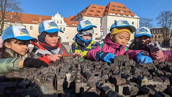Frisch ausgestattet mit ihren neuen Caps waren die Vorschüler der Kita Sachsenspatzen heute (1. März) in der Silberstadt unterwegs – hier am Stadtmodell auf dem Schloßplatz (Foto: K. Wegelt)