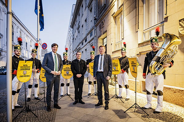 Die Staatssekretäre Conrad Clemens (links) und Dr. Frank Pfeil (rechts) mit Richard Thum (Mitte) und dem Bergmusikkorps Saxonia Freiberg. (Foto: Copyright Felix Zahn photothek.net)